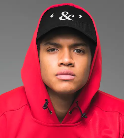 A man wearing a red hoodie and a black cap