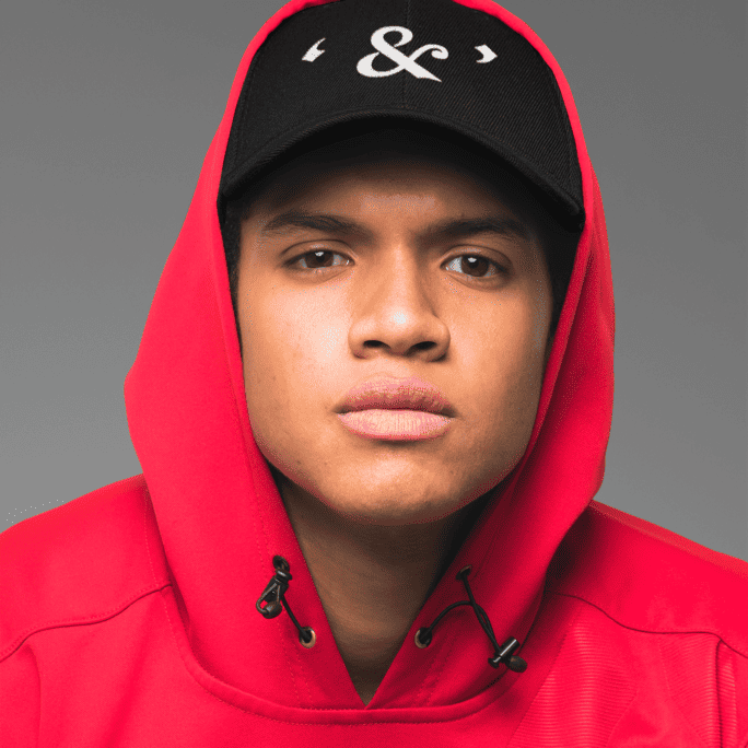 A man wearing a red hoodie and a black cap