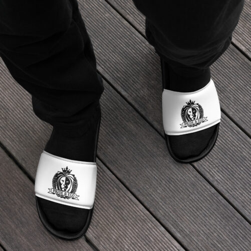 A person wearing black joggers, socks, and slides